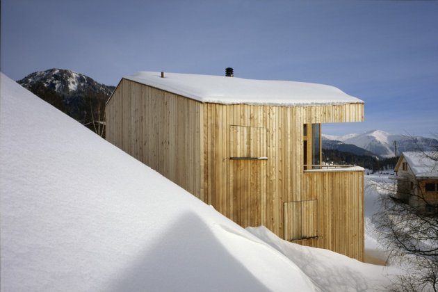 A wooden house in the snow, construction of houses of wood. A big piece of wood carved to set this house in the mountain.    