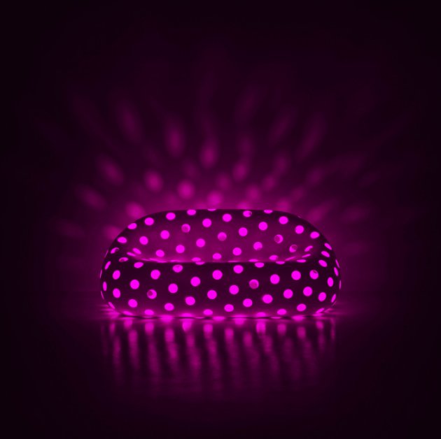 Una moderna butaca de diseño con agujeros que permiten un juego de luz y color 