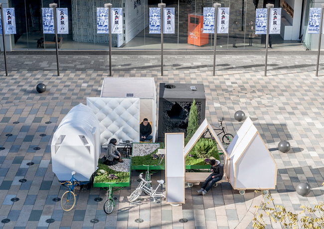 Una casa movil sobre un triciclo hecha con planchas de plástico 