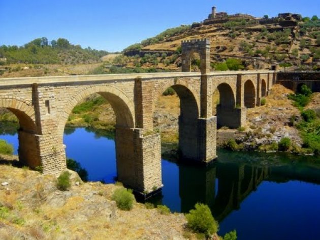 El puente romano de Alcántara. Este puente durará mientras dure el mundo, se leen el dintel del templete donde descansan los restos de su autor. 